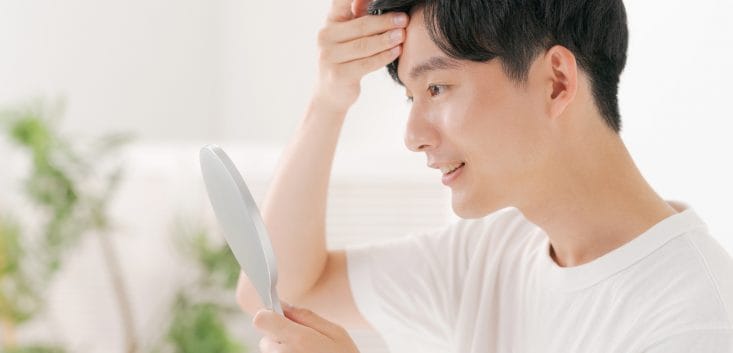 前髪を気にする男性